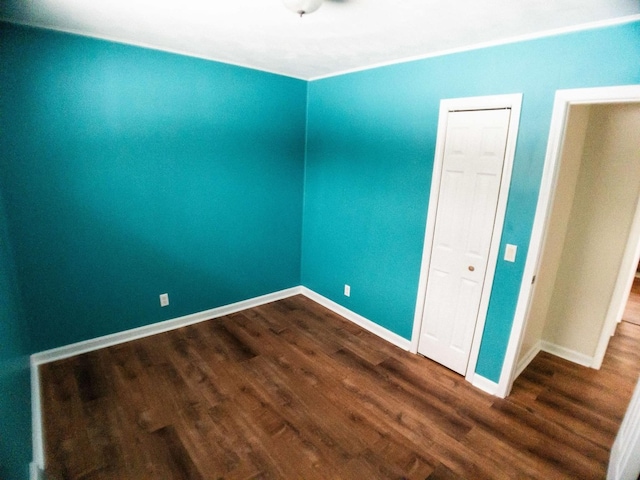 unfurnished room with dark hardwood / wood-style flooring