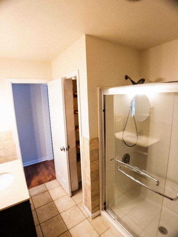 bathroom featuring vanity, tile patterned flooring, and a shower with door