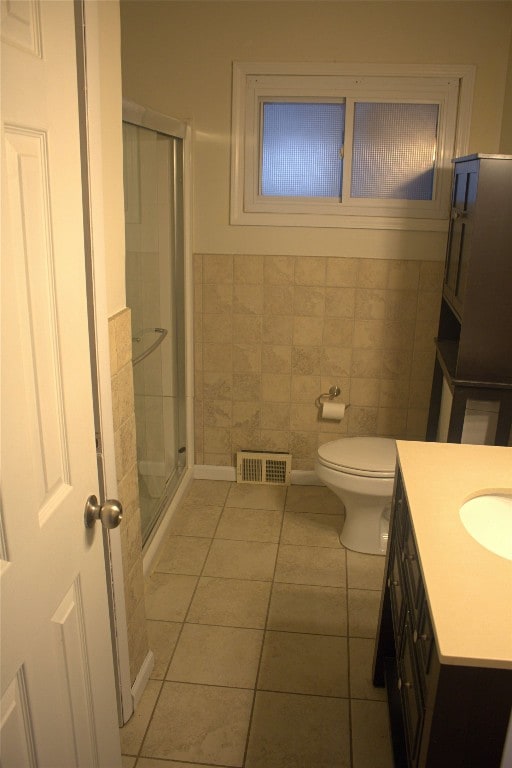 bathroom featuring walk in shower, vanity, tile walls, and tile patterned floors