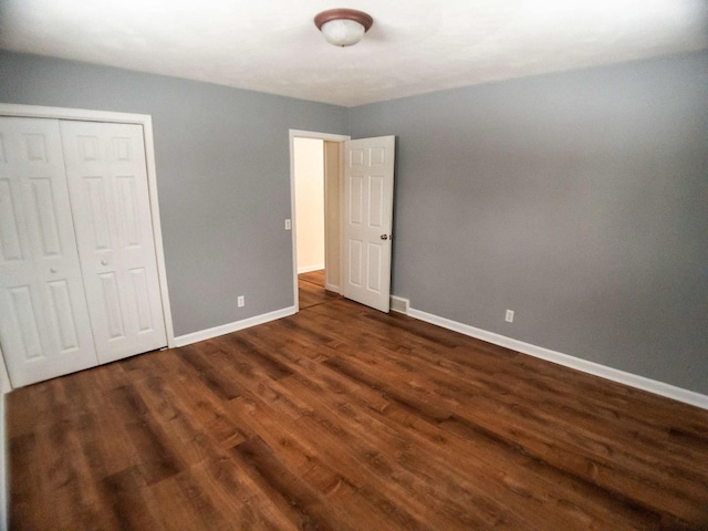 unfurnished bedroom featuring dark wood-type flooring and a closet