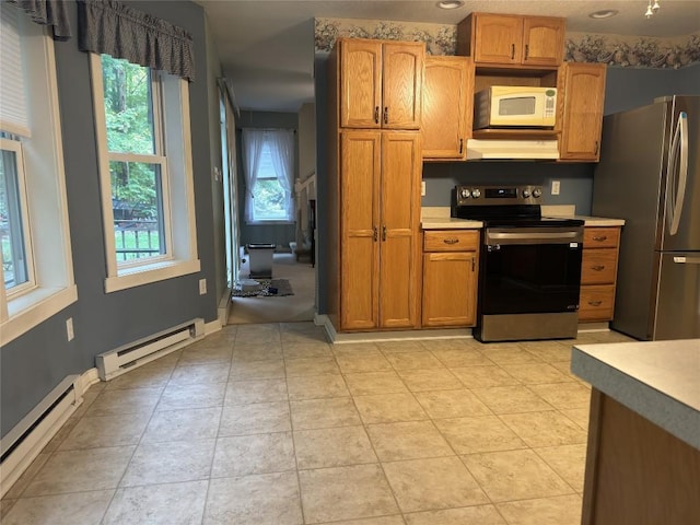 kitchen with baseboard heating, light tile patterned floors, and appliances with stainless steel finishes