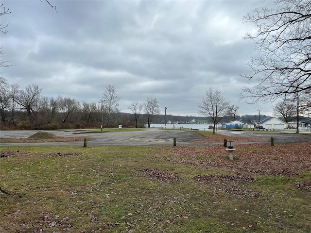 view of yard featuring basketball hoop and a water view