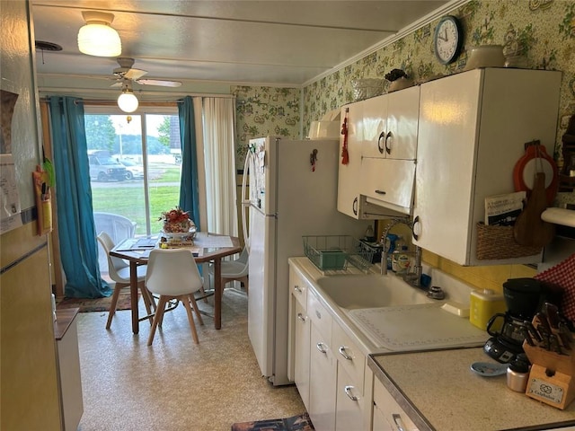 12656 Comstock St, Conneaut Lake, PA 16316 - kitchen with wallpapered walls, light countertops, white cabinetry, freestanding refrigerator, and a ceiling fan