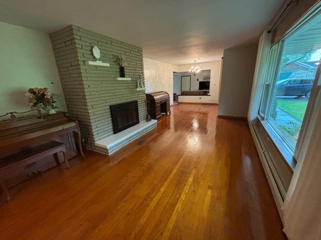 10973 Rte 19, Waterford, PA 16441 - unfurnished living room featuring a fireplace, wood finished floors, a chandelier, and a baseboard radiator