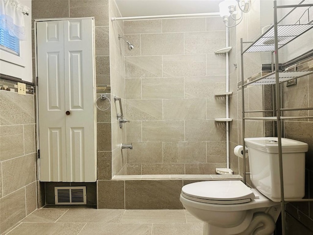 bathroom with tiled shower and toilet