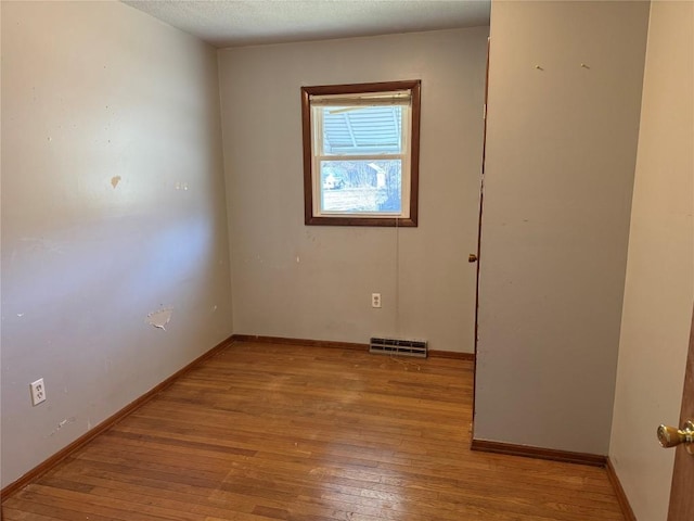 empty room featuring visible vents, baseboards, and light wood-style floors