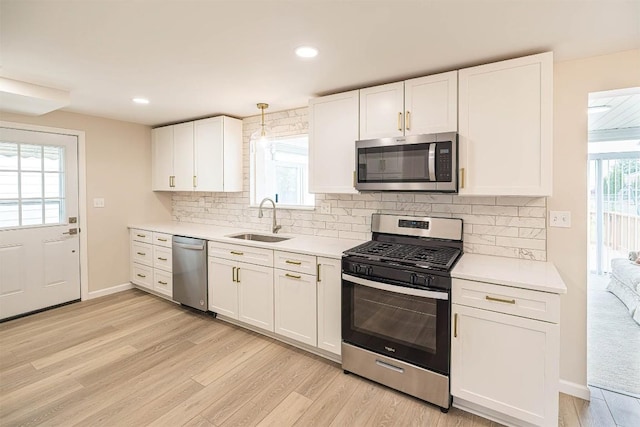 3411 Elmwood St, Erie, PA 16508 - kitchen featuring appliances with stainless steel finishes, a sink, light wood-style floors, white cabinetry, and recessed lighting
