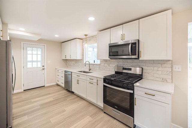 3411 Elmwood St, Erie, PA 16508 - kitchen with appliances with stainless steel finishes, a sink, white cabinetry, light countertops, and baseboards