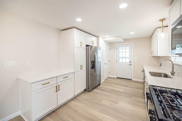 3411 Elmwood St, Erie, PA 16508 - kitchen featuring stainless steel fridge, a sink, baseboards, white cabinetry, and light wood-style flooring