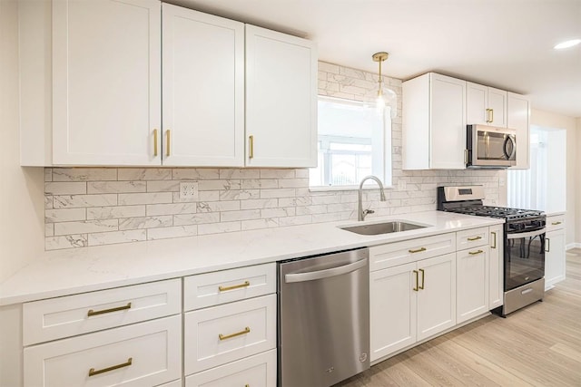 3411 Elmwood St, Erie, PA 16508 - kitchen featuring appliances with stainless steel finishes, a sink, white cabinetry, and light wood finished floors
