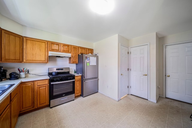 2521 Mccain Ave, Erie, PA 16510 - kitchen with light countertops, under cabinet range hood, brown cabinetry, and stainless steel appliances