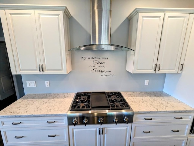 kitchen with white cabinets, wall chimney exhaust hood, light stone counters, and stainless steel gas stovetop