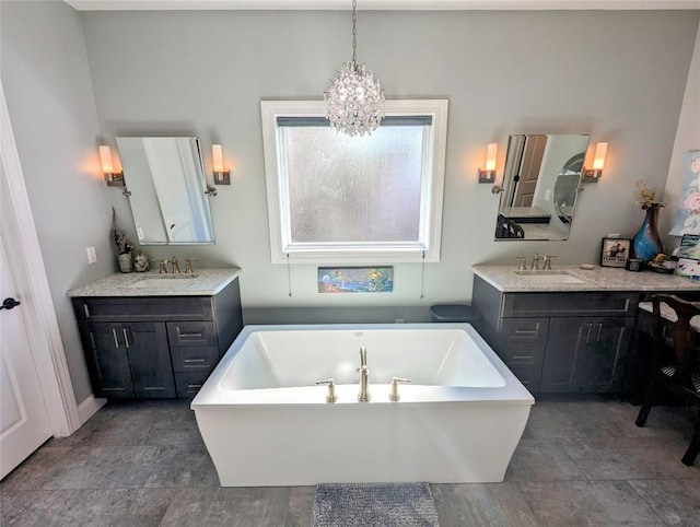 bathroom with a bath, vanity, and an inviting chandelier