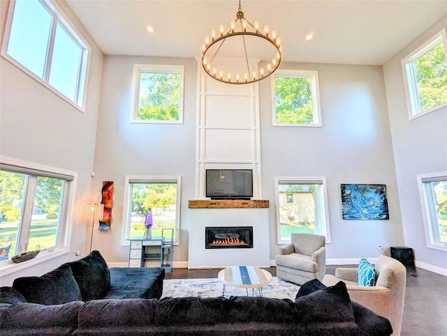 living room featuring a wealth of natural light, a high ceiling, and a chandelier