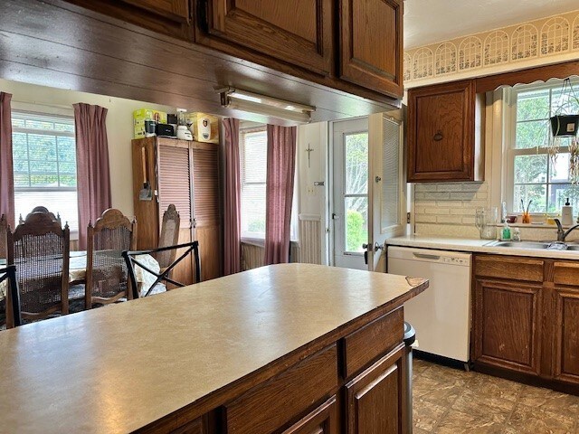 kitchen featuring a sink, dishwasher, and light countertops