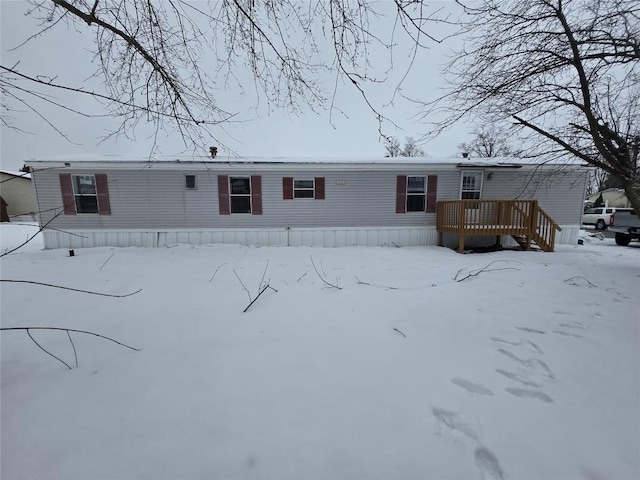 snow covered property with a deck