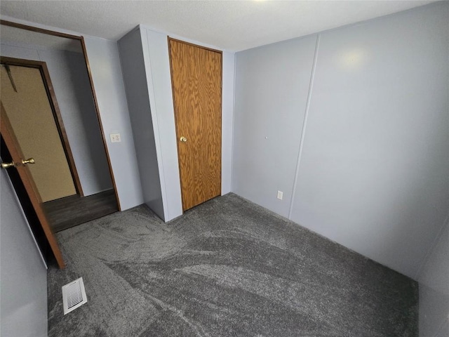 unfurnished bedroom with dark colored carpet