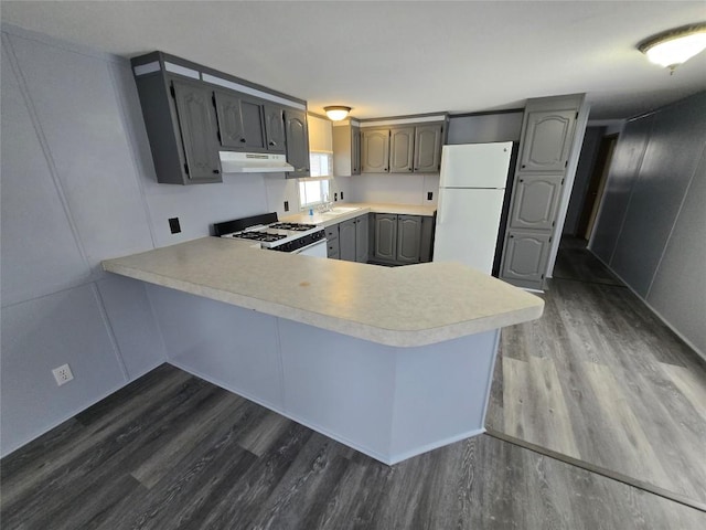 kitchen with white appliances, dark hardwood / wood-style floors, gray cabinetry, and kitchen peninsula