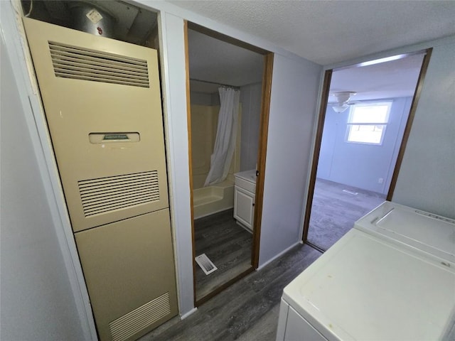 laundry area featuring washing machine and dryer, dark wood-type flooring, and a textured ceiling