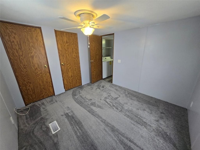 unfurnished bedroom featuring ceiling fan, carpet flooring, separate washer and dryer, and multiple closets