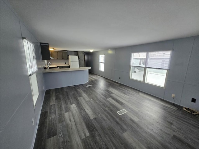 unfurnished living room with dark wood-type flooring and sink