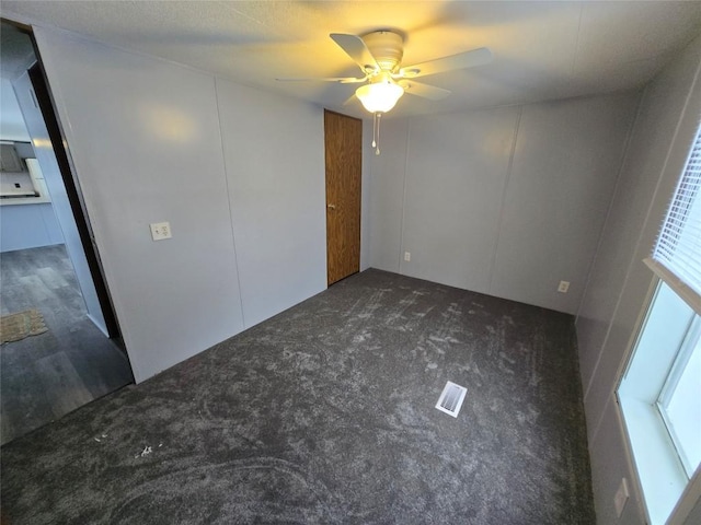 carpeted spare room with ceiling fan