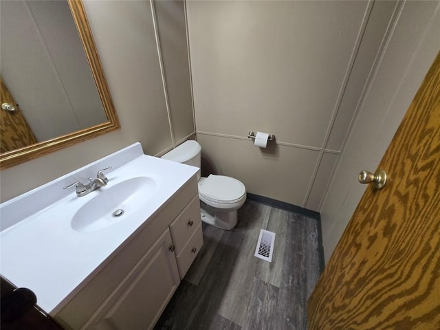 bathroom featuring toilet, hardwood / wood-style floors, and vanity