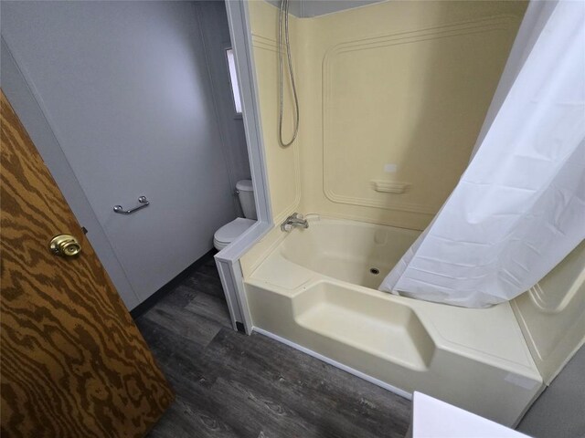 bathroom featuring toilet, wood-type flooring, and washtub / shower combination