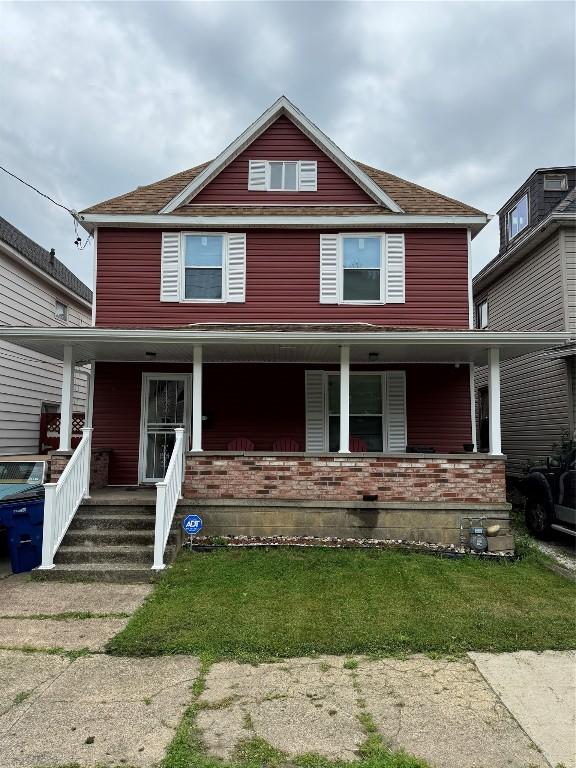 549 E 5th St, Erie, PA 16507 - american foursquare style home with covered porch, a front lawn, and brick siding