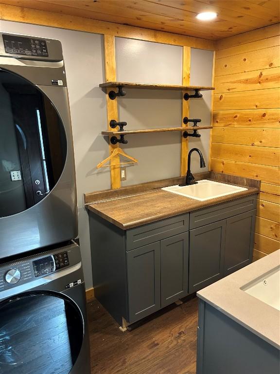 11667 Lakeland Dr, Conneaut Lake, PA 16316 - washroom featuring stacked washer and dryer, dark wood-style floors, wooden ceiling, a sink, and cabinet space