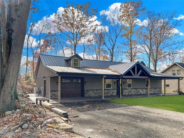 11667 Lakeland Dr, Conneaut Lake, PA 16316 - view of front of property with an attached garage, aphalt driveway, stone siding, and metal roof