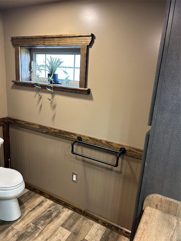 11667 Lakeland Dr, Conneaut Lake, PA 16316 - bathroom with a wainscoted wall, toilet, and wood finished floors
