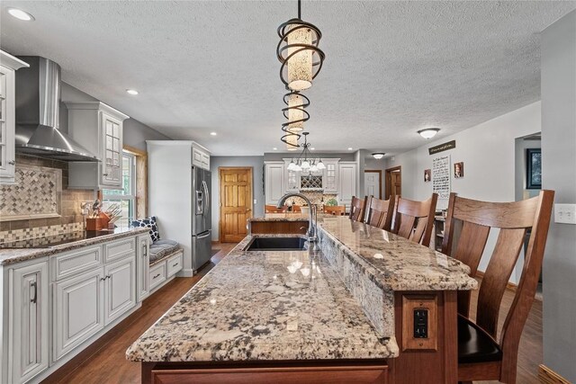 18376 Barber Rd, Meadville, PA 16335 - kitchen featuring wall chimney range hood, stainless steel fridge, a textured ceiling, black electric stovetop, and a large island