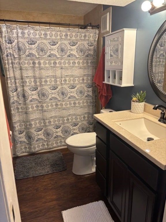 bathroom with a shower with curtain, vanity, hardwood / wood-style floors, and toilet