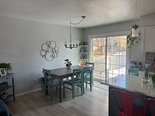 dining space featuring hardwood / wood-style flooring and a chandelier