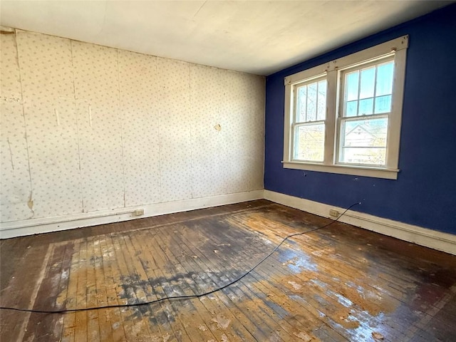 empty room with hardwood / wood-style floors and baseboards
