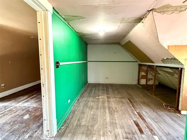 bonus room with lofted ceiling, hardwood / wood-style flooring, and baseboards