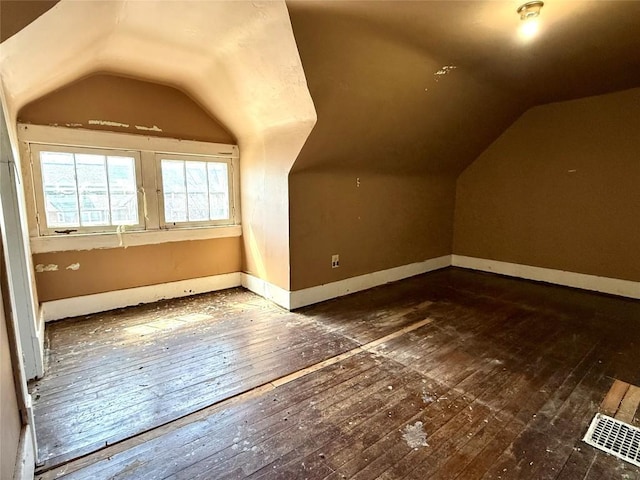 bonus room with baseboards, lofted ceiling, and hardwood / wood-style flooring