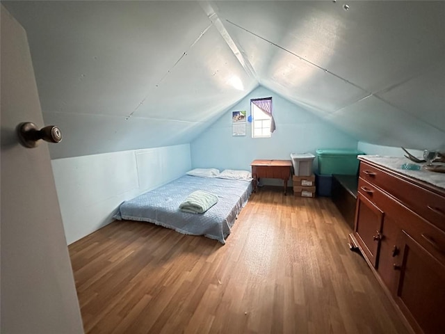 bedroom featuring wood-type flooring and vaulted ceiling