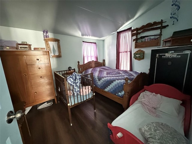 bedroom with vaulted ceiling and dark hardwood / wood-style floors