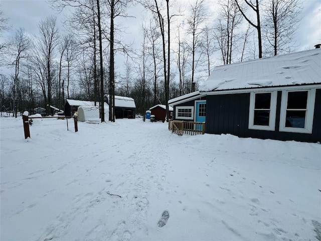 snowy yard with an outbuilding