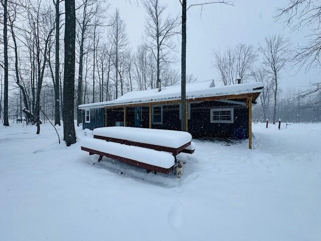 view of snow covered back of property