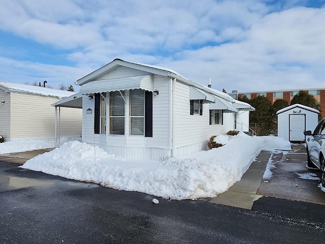 snow covered property featuring a storage shed