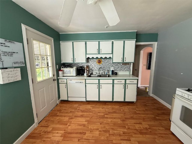 3508 Emerson Ave, Erie, PA 16508 - kitchen with white appliances, arched walkways, light countertops, white cabinetry, and decorative backsplash
