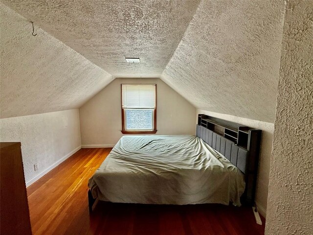 3508 Emerson Ave, Erie, PA 16508 - bedroom featuring a textured ceiling, a textured wall, wood finished floors, and vaulted ceiling