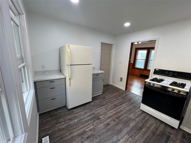 kitchen featuring white refrigerator, dark wood-type flooring, gray cabinetry, and gas range