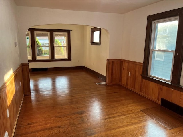 spare room with a healthy amount of sunlight and dark hardwood / wood-style flooring