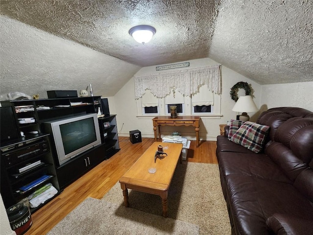 living room featuring lofted ceiling, a textured ceiling, and wood-type flooring