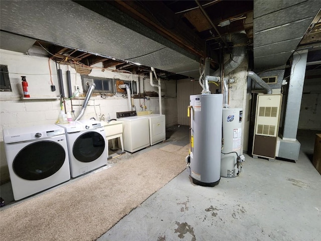 basement with sink, washer and clothes dryer, and gas water heater