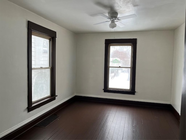 unfurnished room featuring ceiling fan, a healthy amount of sunlight, and dark hardwood / wood-style floors